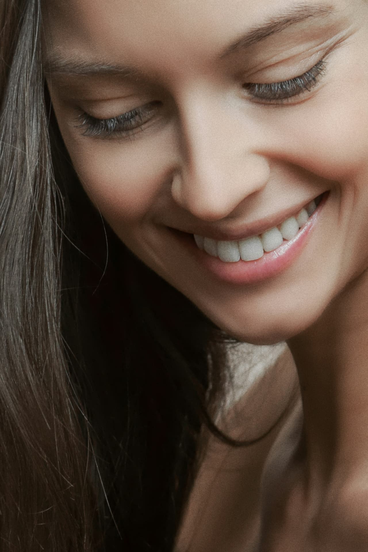 Close-up of a woman smiling naturally, showing bright, evenly shaped front teeth