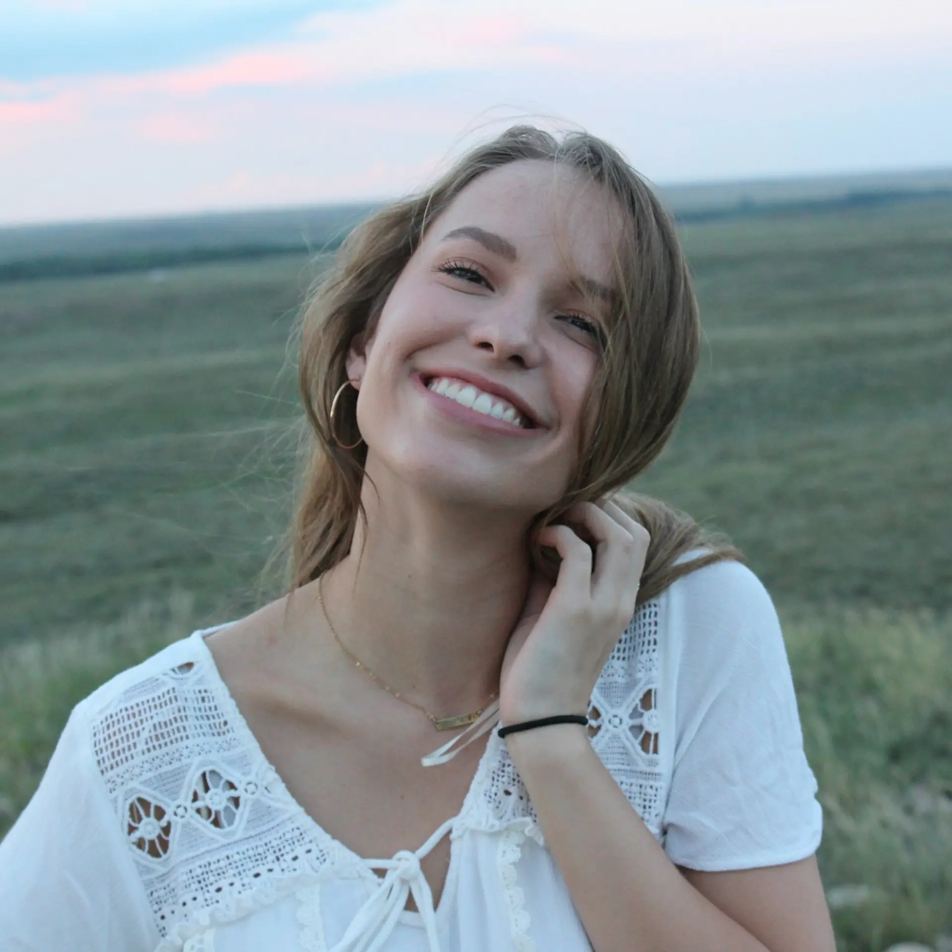 woman smiling while taking photo during daytime