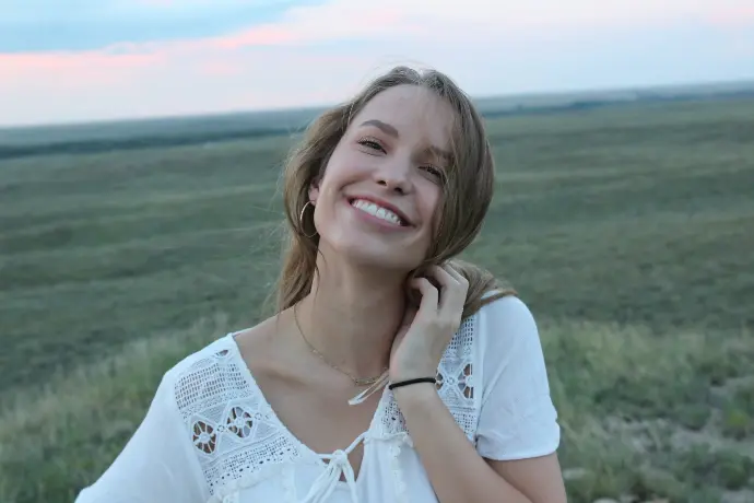 woman smiling while taking photo during daytime